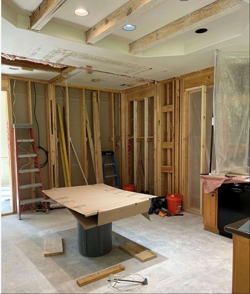 Kitchen under construction with exposed framing and ladders