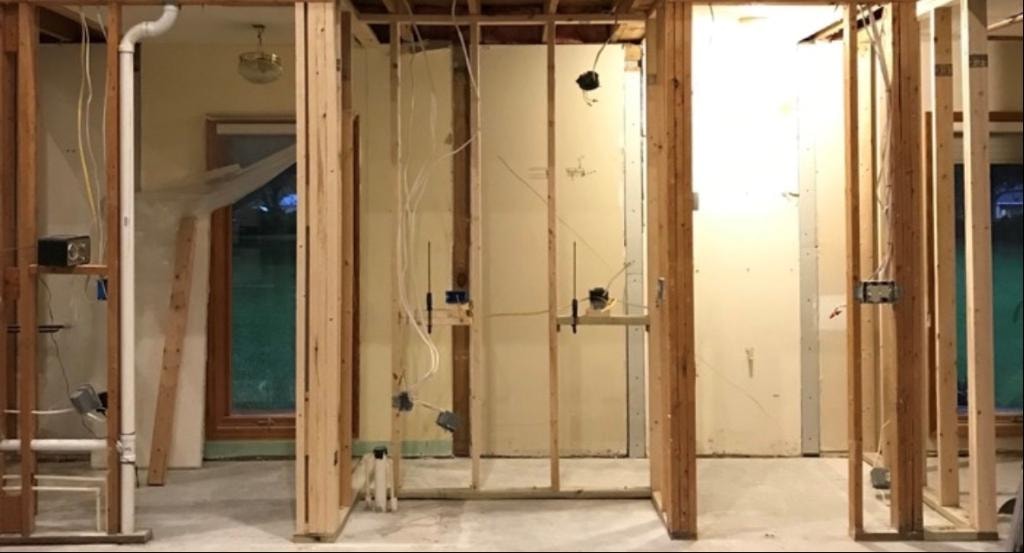 Kitchen renovation with exposed wall framing and wiring