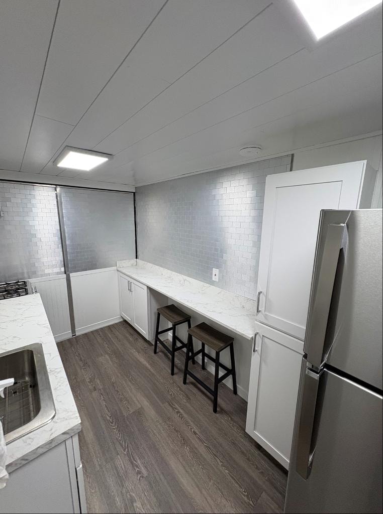 Wide view of trailer interior with counter seating and sink
